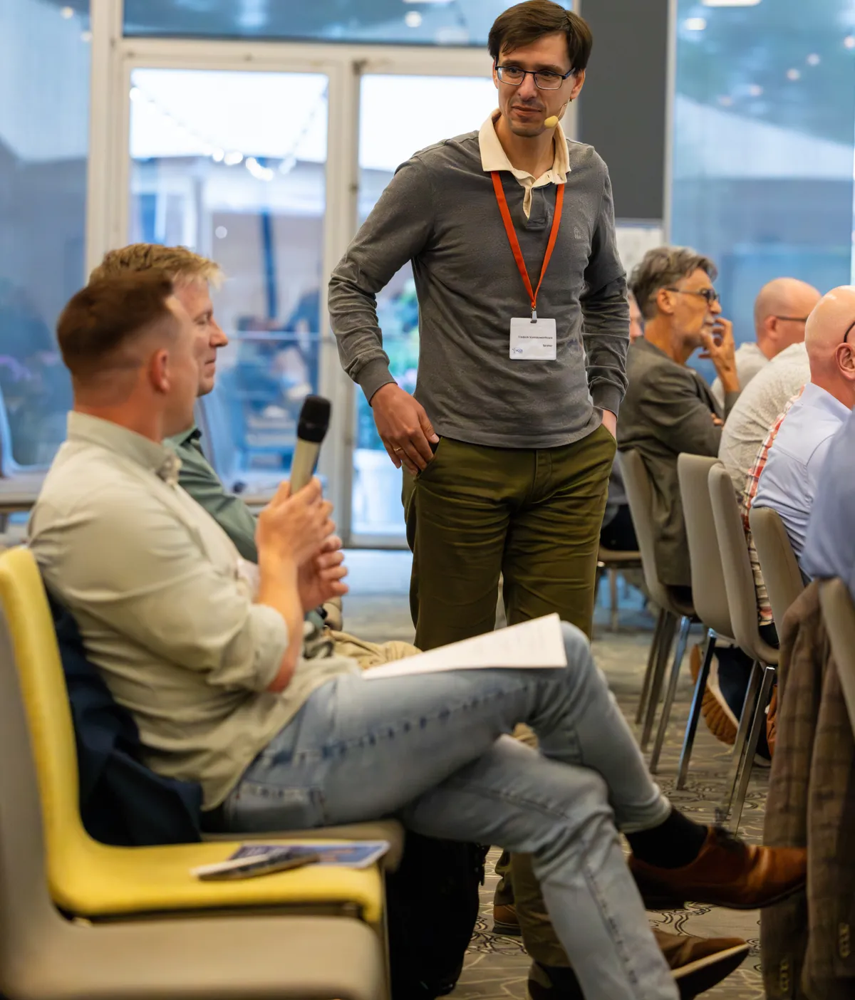 Frederik Vannieuwenhuyse engaging directly with a participant during an interactive session at NCOI Dag van de Projectmanager 2026